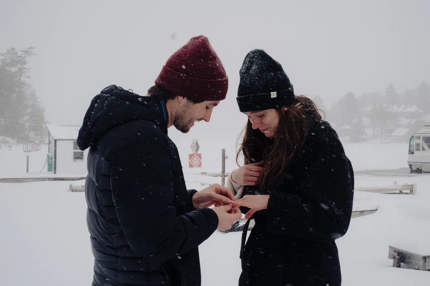 Hugh placing the engagement ring on Rachel's finger in the snow